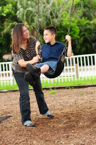 Mãe e filho no parque no balanço — Fotografia de Stock