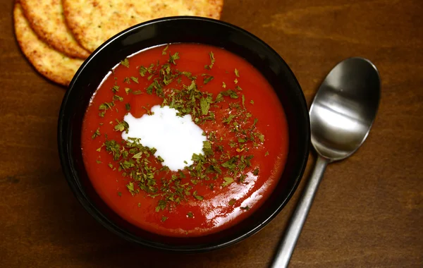 Zuppa di pomodoro su uno sfondo di legno rustico — Foto Stock