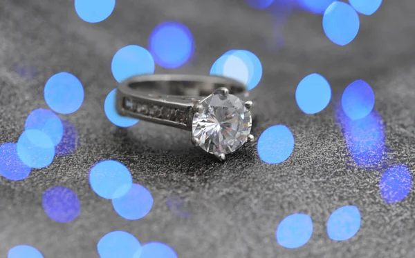 与抽象的蓝色灯光的钻石订婚戒指 — 图库照片