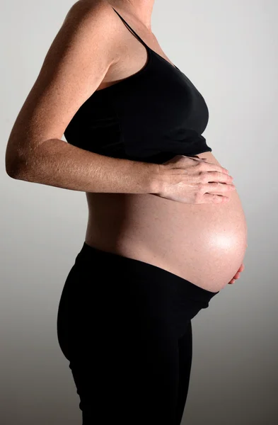 妊娠中の母親のおなかの上の手で — ストック写真