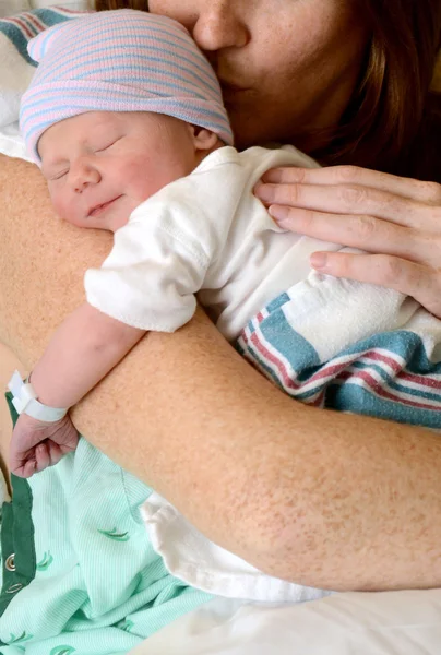 Mamma kysser leende nyfött barn — Stockfoto