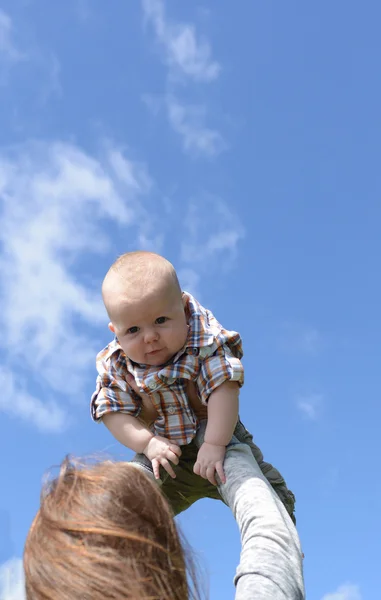 Modern som håller pojke mot blå himmel — Stockfoto