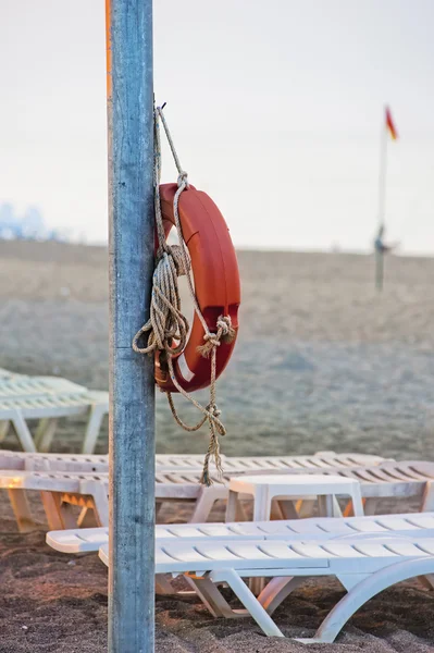 Lifebuoy hanging on a pole on the public beach. — Stock Photo, Image