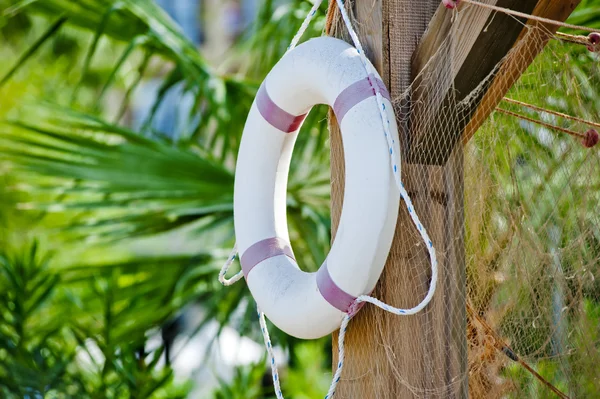 White life preserver hanging on a wooden post — Stock Photo, Image