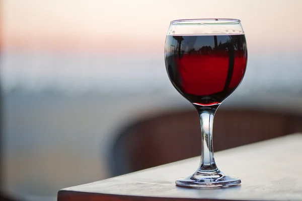 Een glas rode wijn bij zonsondergang. — Stockfoto