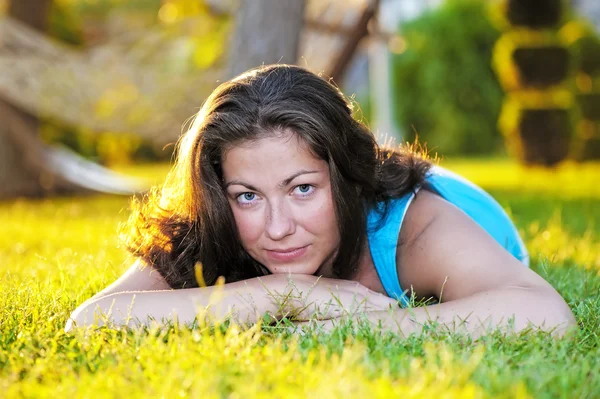 Brunette meisje liggen op het gras — Stockfoto