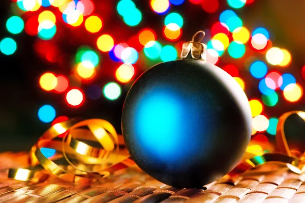 Bola de Natal azul no fundo de luzes borradas guirlandas . — Fotografia de Stock