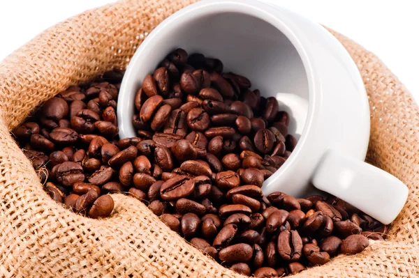 White cup in a bag of coffee beans. — Stock Photo, Image