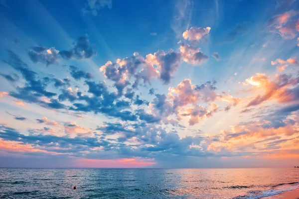 Un hermoso cielo al atardecer sobre el mar. — Foto de Stock