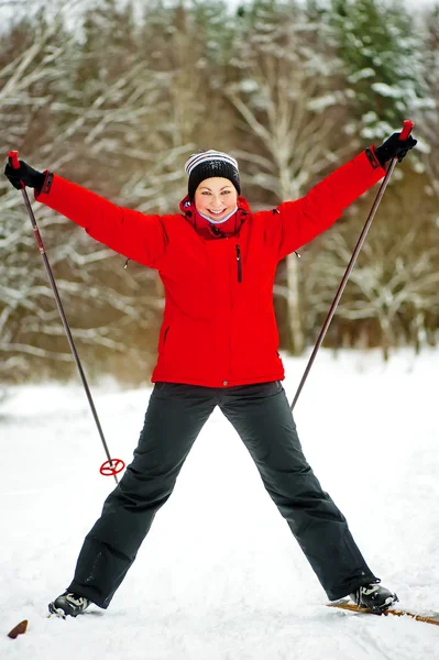 Gelukkig meisje die zich voordeed op ski's in de winter bossen. — Stockfoto