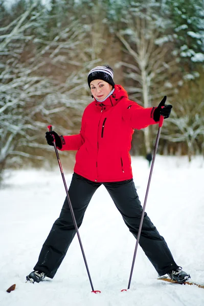 Gelukkig meisje die zich voordeed op ski's in de winter bossen. — Stockfoto
