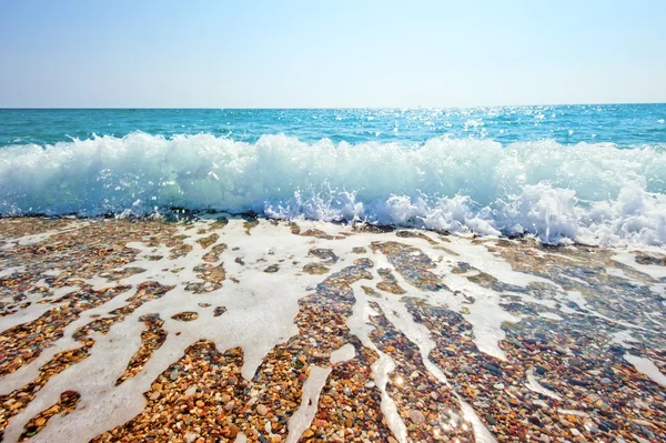 Splash de mousse de mer sur une plage de sable fin — Photo