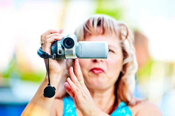 Femme tourne la vidéo avec intérêt pour le mini caméscope — Photo