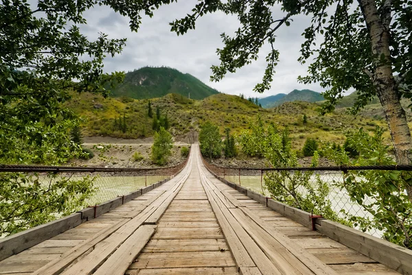 Ponte stradale sospeso in legno sul fiume Katun. Montagne Altai, Russia . — Foto Stock
