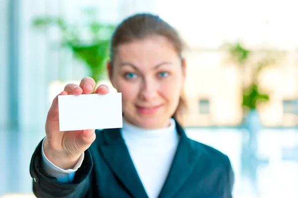 Happy brunette shows a blank business card — Stock Photo, Image