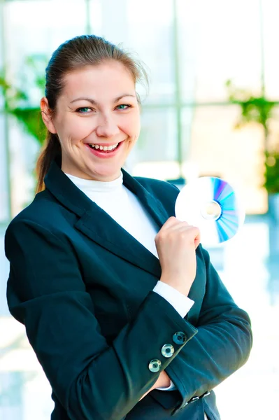 Девушка в деловом костюме держит руку на компакт-диске — стоковое фото