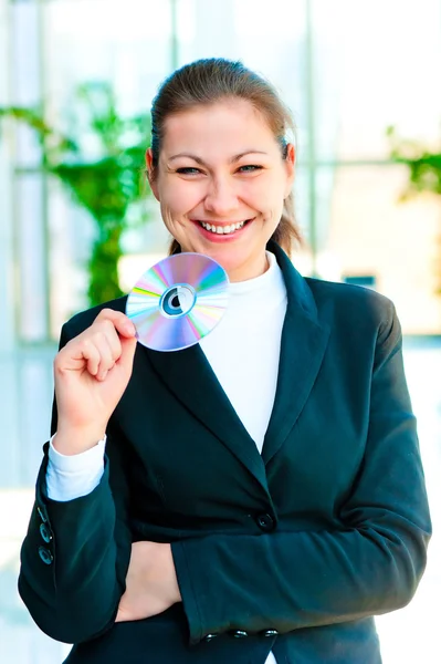 Young happy business woman holding compact disc — Stock Photo, Image