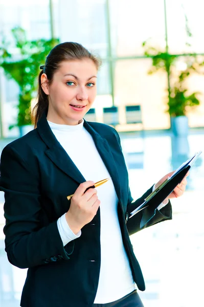 Young happy business woman with a folder and pen in hand — Stock Photo, Image