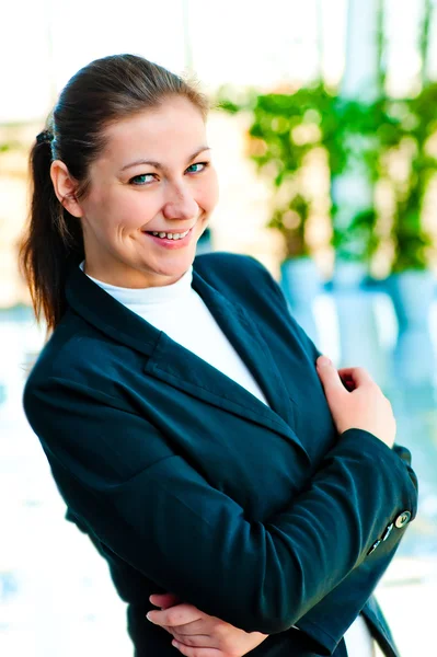 Retrato de una exitosa mujer de negocios sonriendo en el fondo de un interior borroso de la oficina —  Fotos de Stock