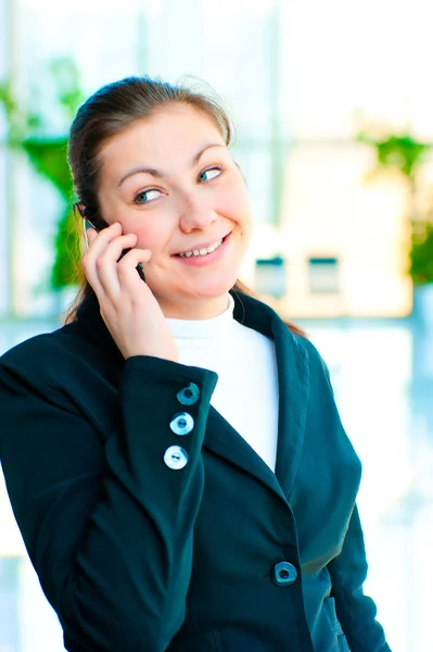 Jeune femme d'affaires heureuse parlant au téléphone — Photo