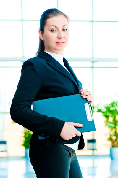 Una chica sonriente sosteniendo una carpeta de la oficina del gerente —  Fotos de Stock