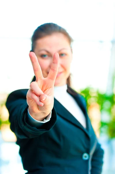 Chica en un traje de negocios mostrando gesto mano victoria —  Fotos de Stock