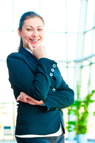 Porträt eines lächelnden erfolgreichen Unternehmens vor dem Hintergrund eines verschwommenen Bürointerieurs — Stockfoto