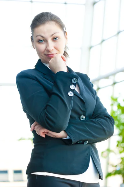 Portret van succesvolle zakelijke vrouw die lacht op de achtergrond van een wazig kantoor interieur — Stockfoto