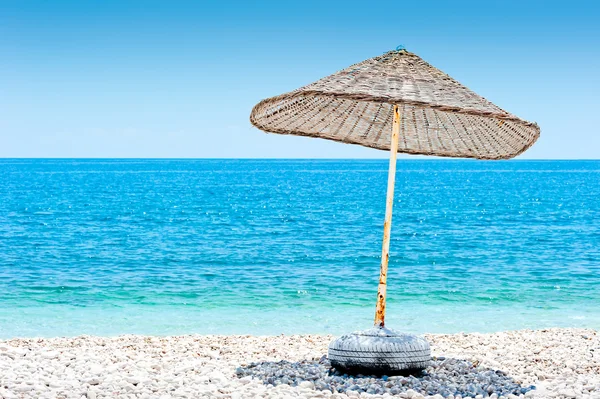 Sombrilla de mimbre solitario en la playa —  Fotos de Stock