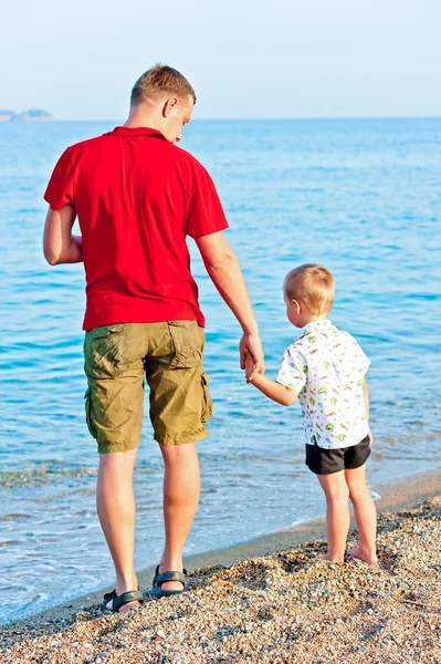 Father and son admiring the sea at sunset — Stock Photo, Image