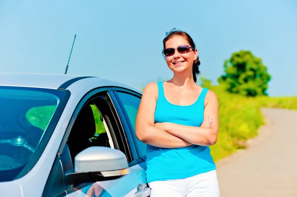 Mooie jonge vrouw staat in de buurt van de nieuwe auto — Stockfoto