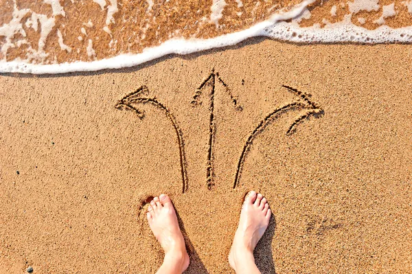 Piedi nudi degli uomini nella sabbia e le frecce — Foto Stock