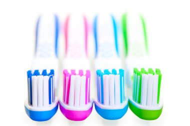 four new multi-colored toothbrushes are on a white background clipart