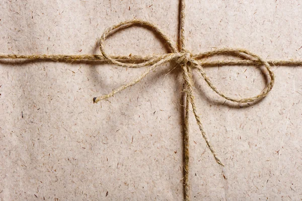 Parcel wrapped in brown paper and tied with twine — Stock Photo, Image