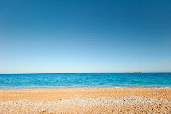 Άμμο και βότσαλο και μια ήσυχη, ήρεμη θάλασσα — Φωτογραφία Αρχείου