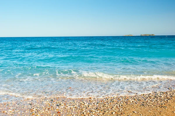 Salpicadura de espuma de mar en una playa de arena — Foto de Stock