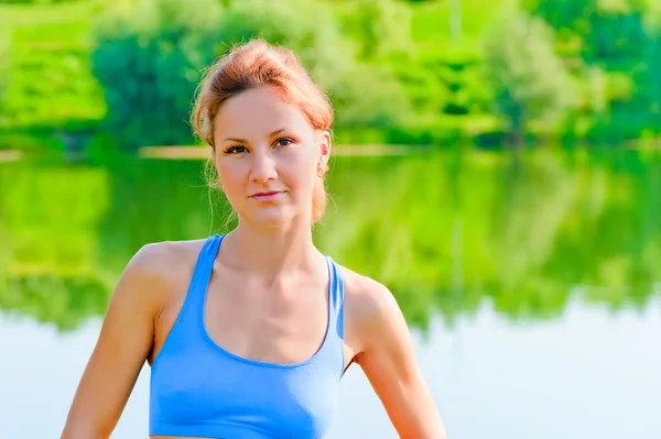 一个美丽的女孩的湖的背景上体育性质的肖像 — 图库照片