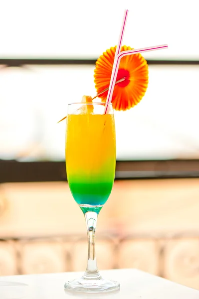Bright alcoholic cocktail in a glass with decorations on the edge of the table — Stock Photo, Image