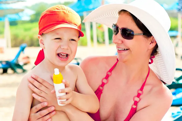 Mutter und Sohn am Strand, um die Haut vor Sonnencreme zu schützen — Stockfoto