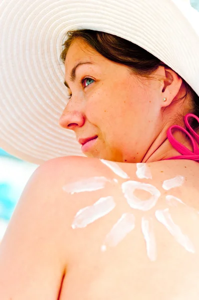 Meisje in de hoed op het strand beschermt de huid tegen de zon — Stockfoto