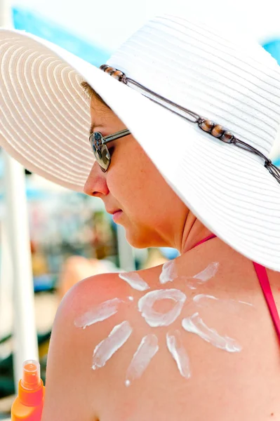 Soleil sur l'épaule d'une jeune fille peint crème solaire — Photo