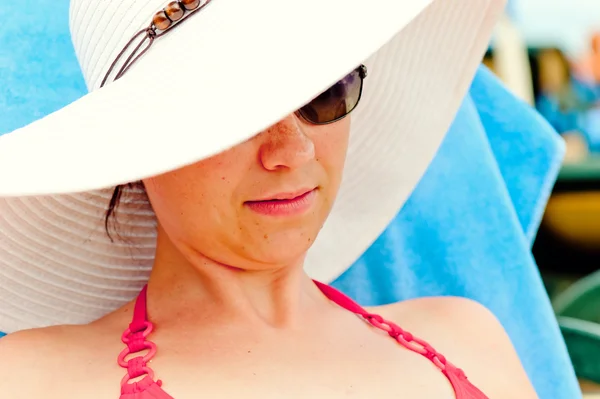 Retrato de una chica en un sombrero blanco con un ala ancha en la playa — Foto de Stock