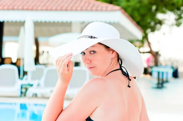 Woman in a bikini holds the hand his hat — Stock Photo, Image