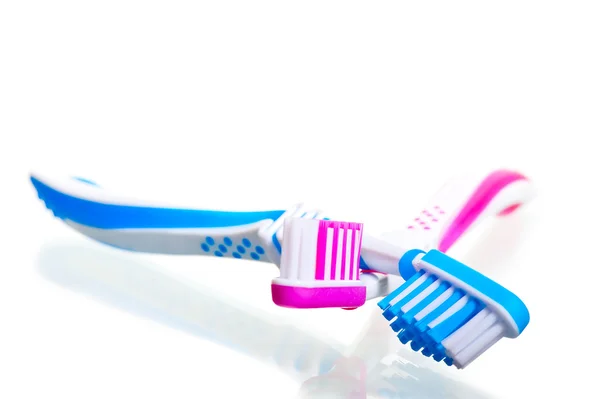 Twee tandenborstels gekruist op een witte achtergrond — Stockfoto