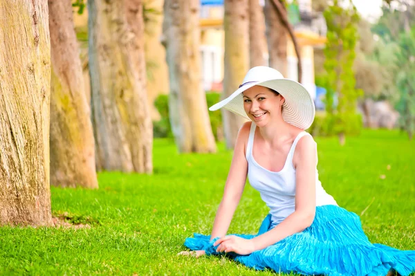 Şen şakrak gülüyor ve çim üzerinde oturan kız — Stok fotoğraf