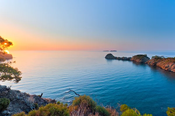 Sole che sorge su un mare calmo nella splendida baia — Foto Stock