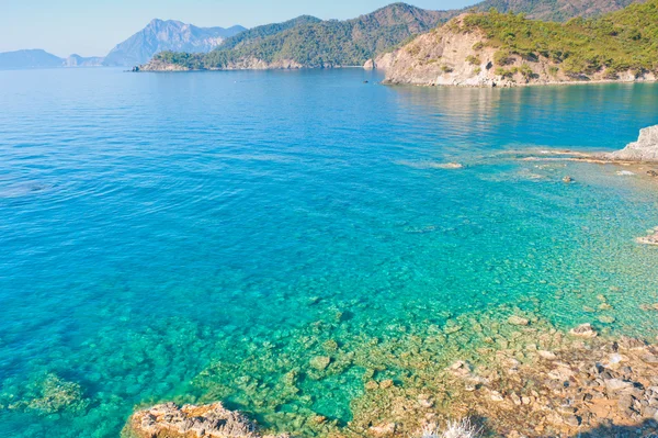 Duidelijk turkoois water en rotsachtige kust — Stockfoto