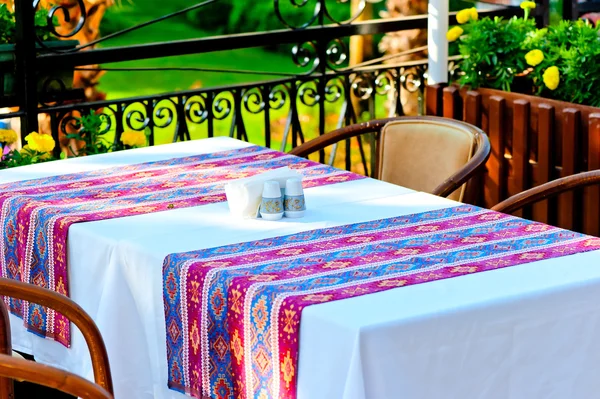 Table covered with a tablecloth in a restaurant with Turkish ornament — Stock Photo, Image