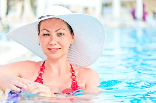 Femme dans une piscine bleue eau — Photo