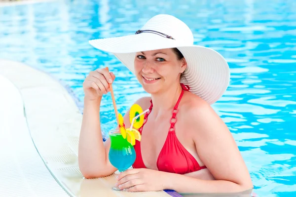 Chica en la piscina con un cóctel sonríe — Foto de Stock